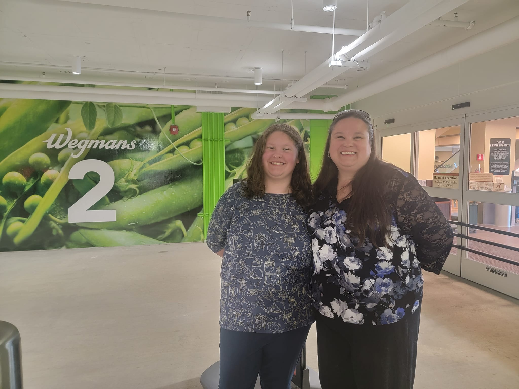 a mother and her daughter stand in underground parking garage at a Wegmans grocery store