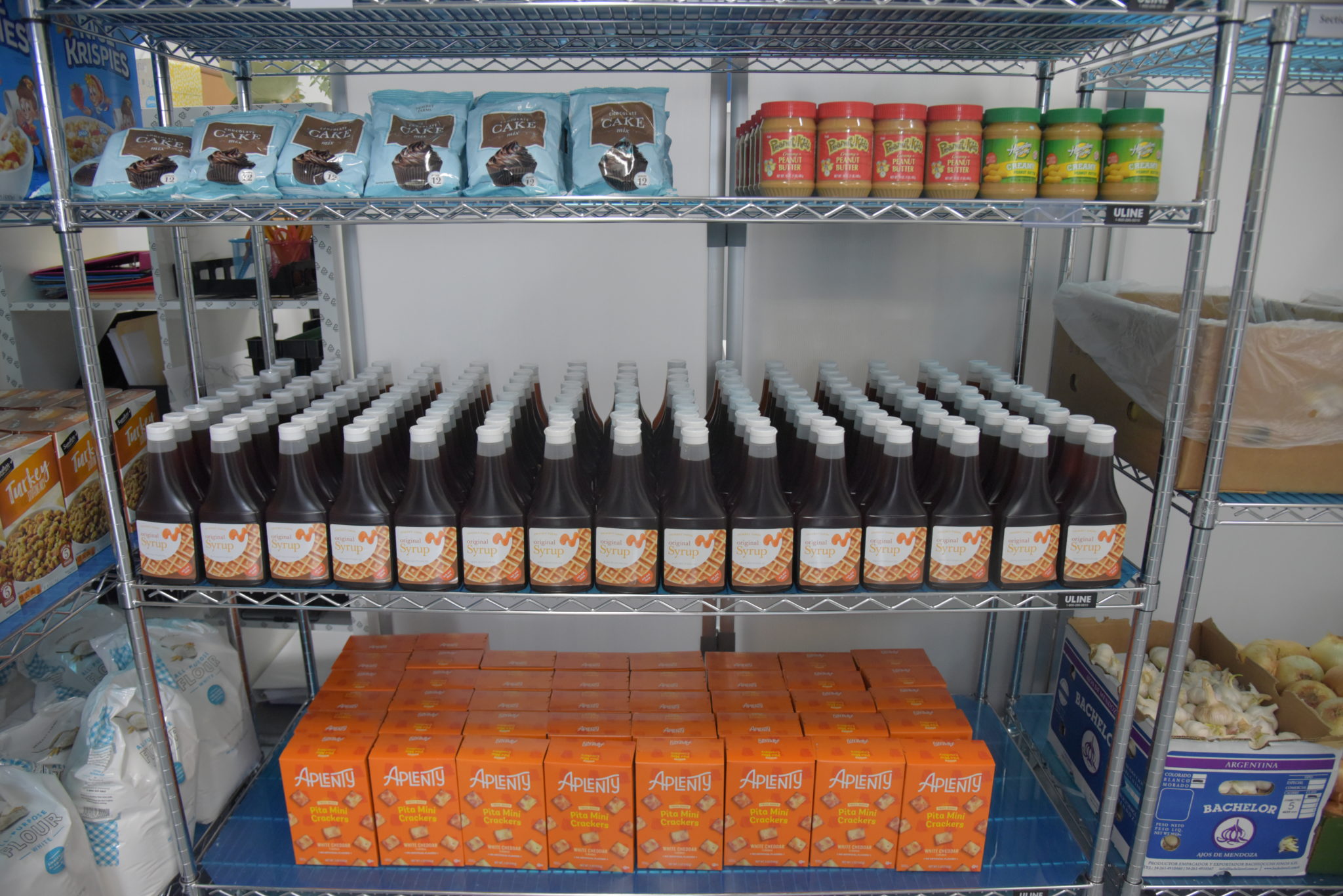 a silver shelf holding nonperishable food items, like honey and baking goods