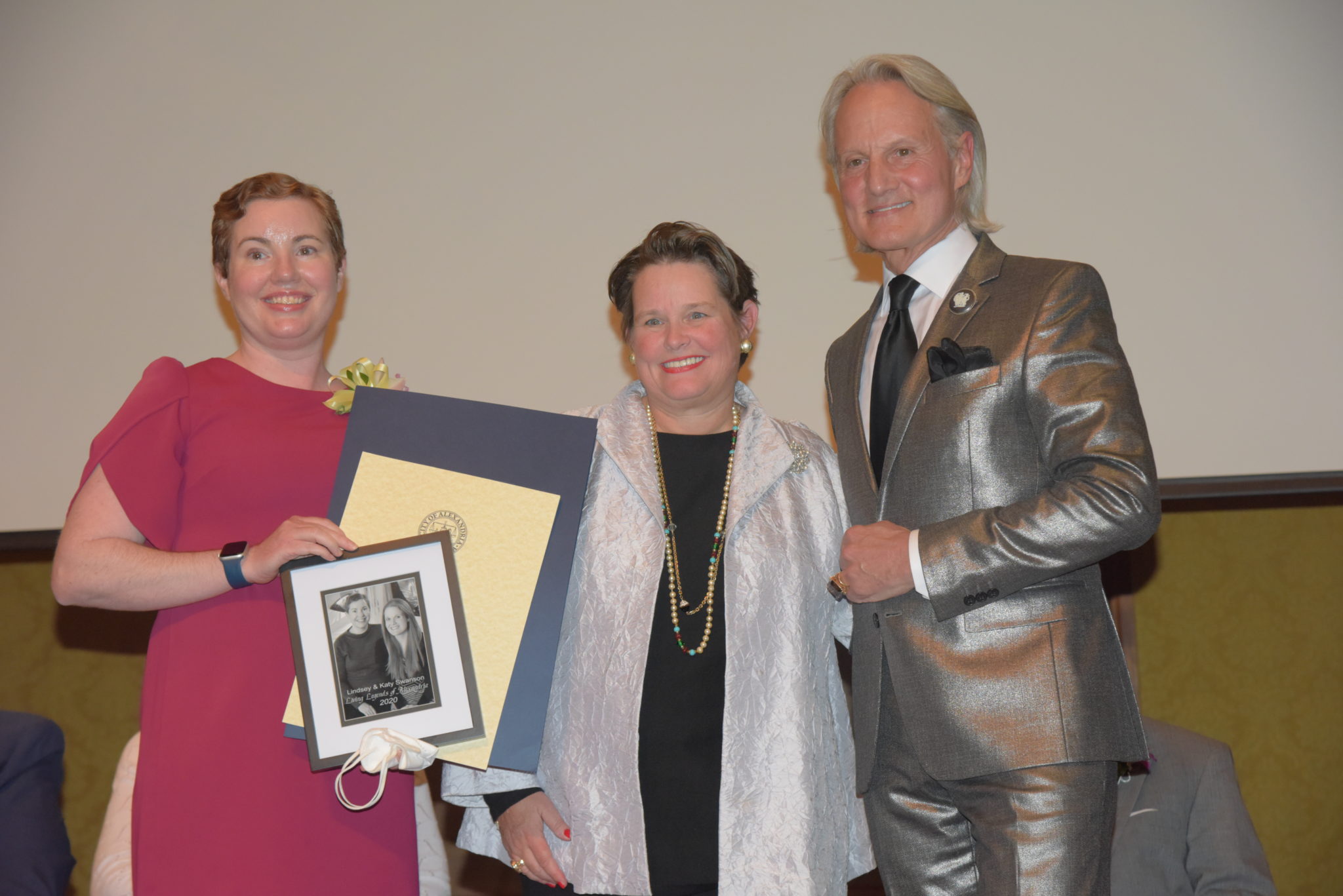 Lindsey Swanson holds photo and certificates and stands next to Mary Wadland and Monte Durham