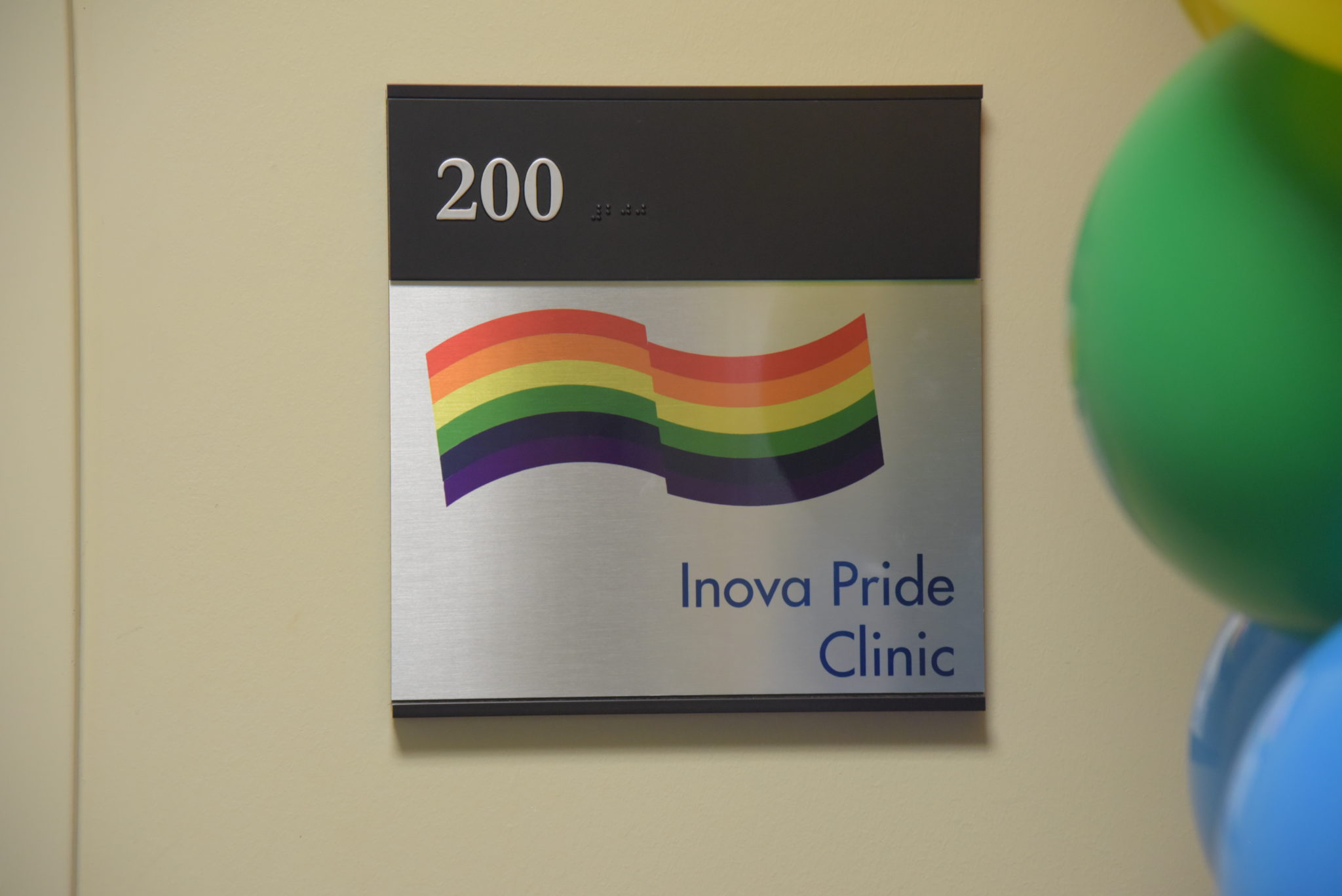 a sign on a door that reads 200, Inova Pride Clinic, with a rainbow flag on it