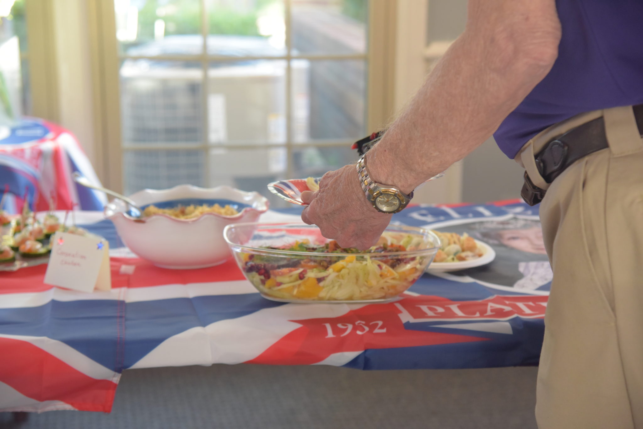 coronation chicken is a chicken casserole being scooped by a man onto a plate