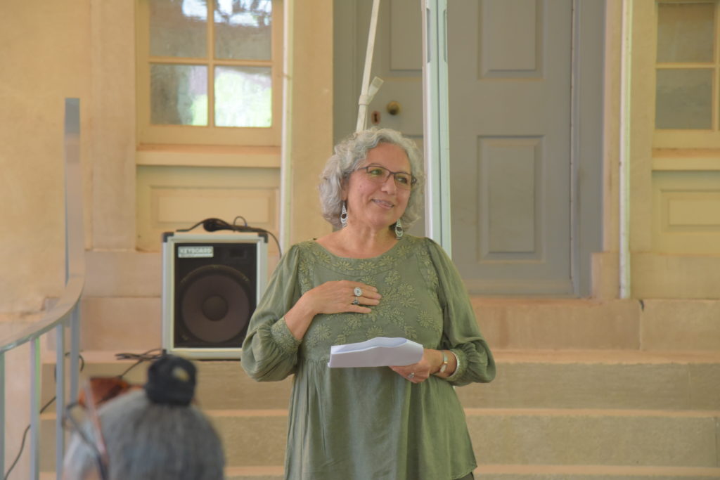 Alexandria's poet laureate Zeina Azzam stands on the back terrace of Carlyle House with her hand to her chest