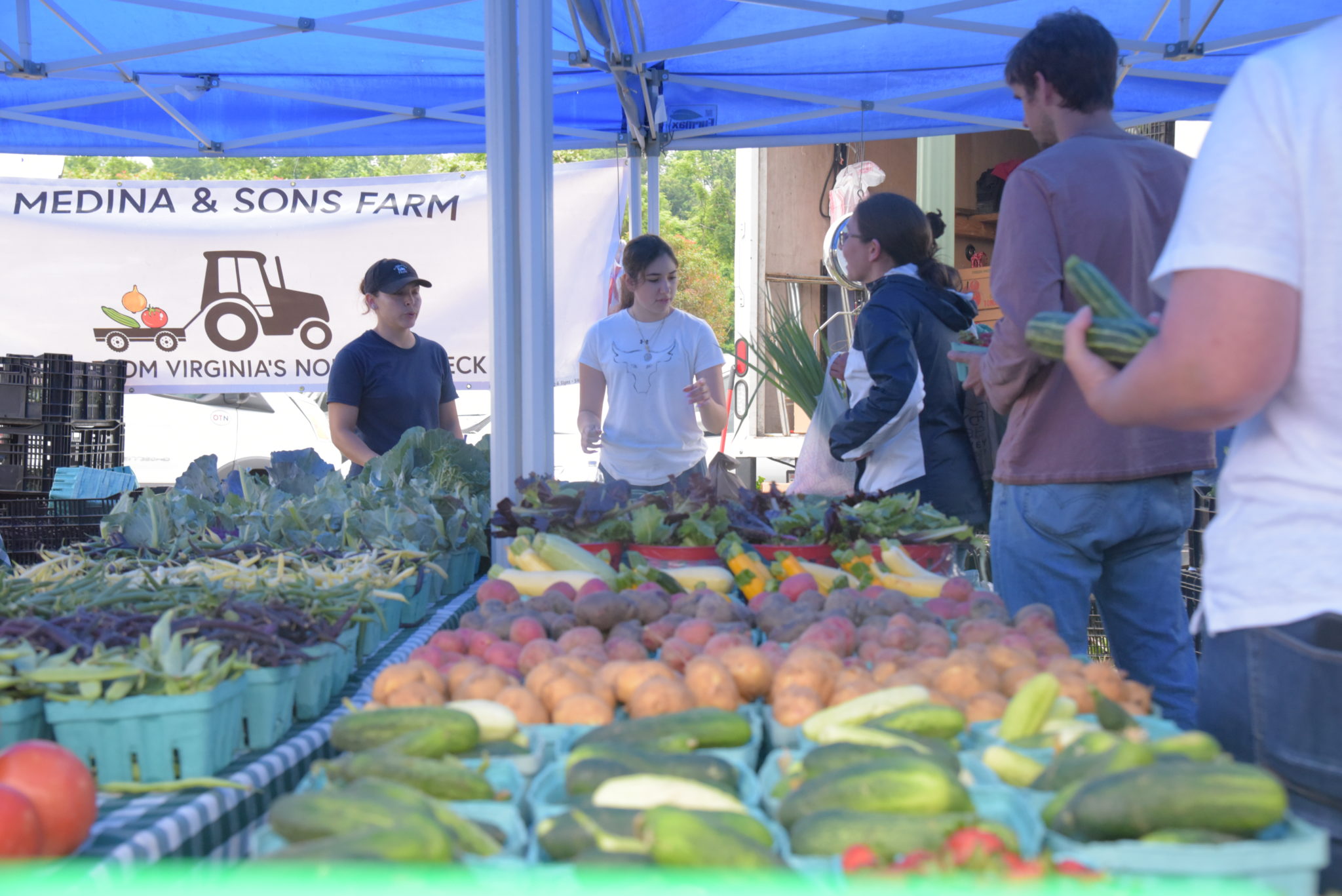 a table full of fresh vegetables at the west end farmers market