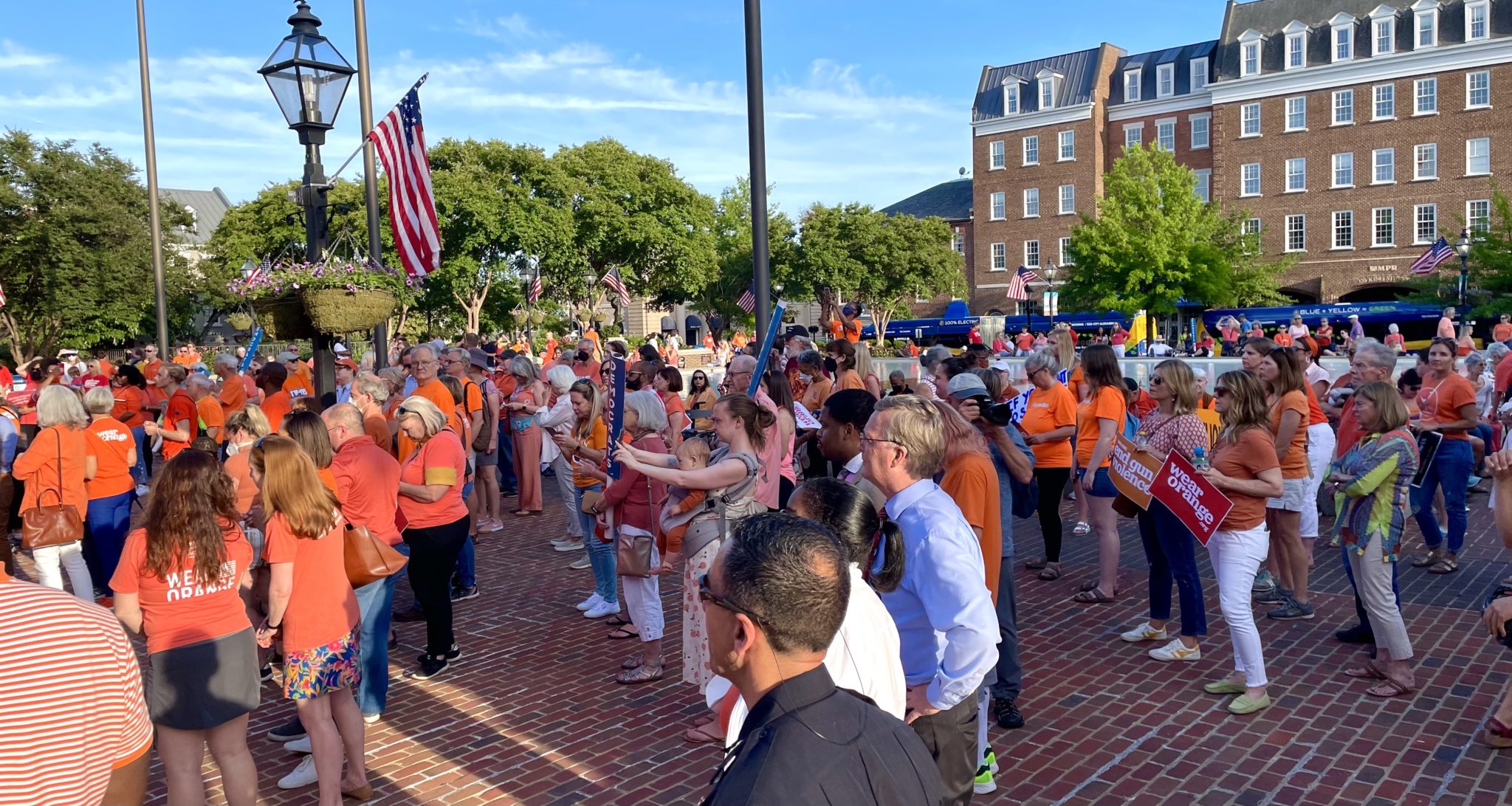 a group of people gathered in Alexandria's Market Square all wearing orange t shirts in support of gun violence victims