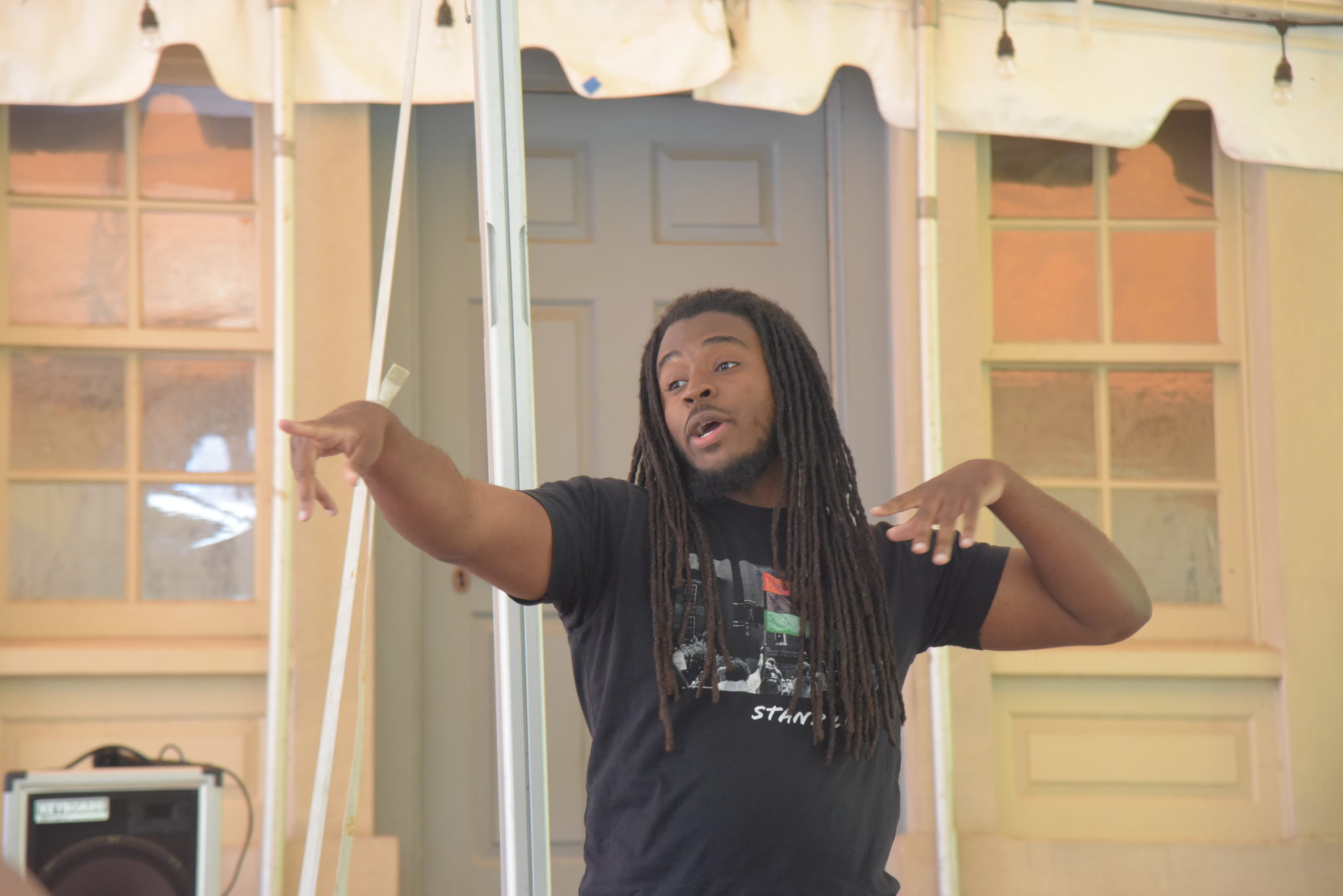 poet khalil houston stands with his hands pointing out to a crowd in front of him