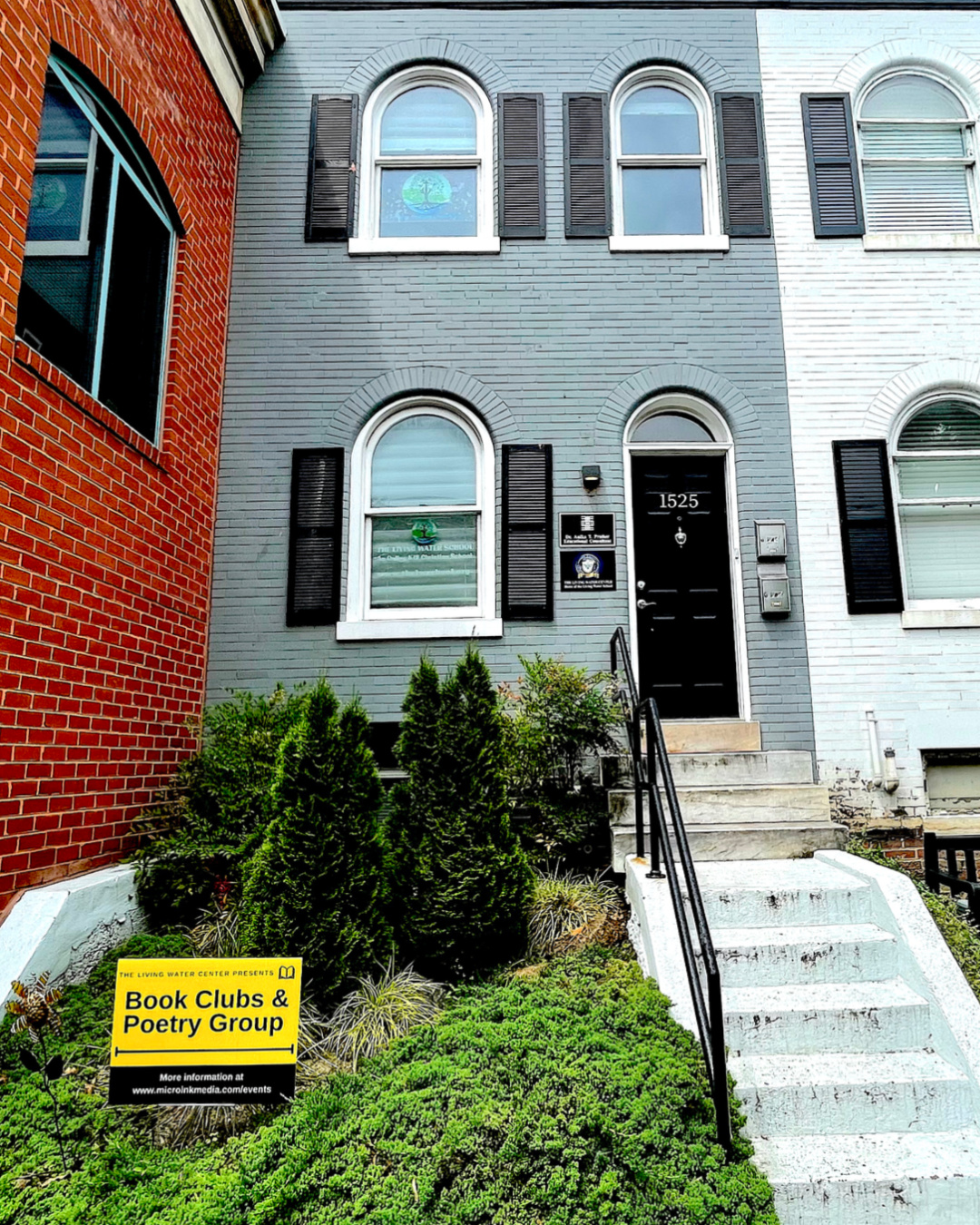 an image of an Old Town townhouse, two upper windows, one lower window next to a black door, the face of the building is baby blue