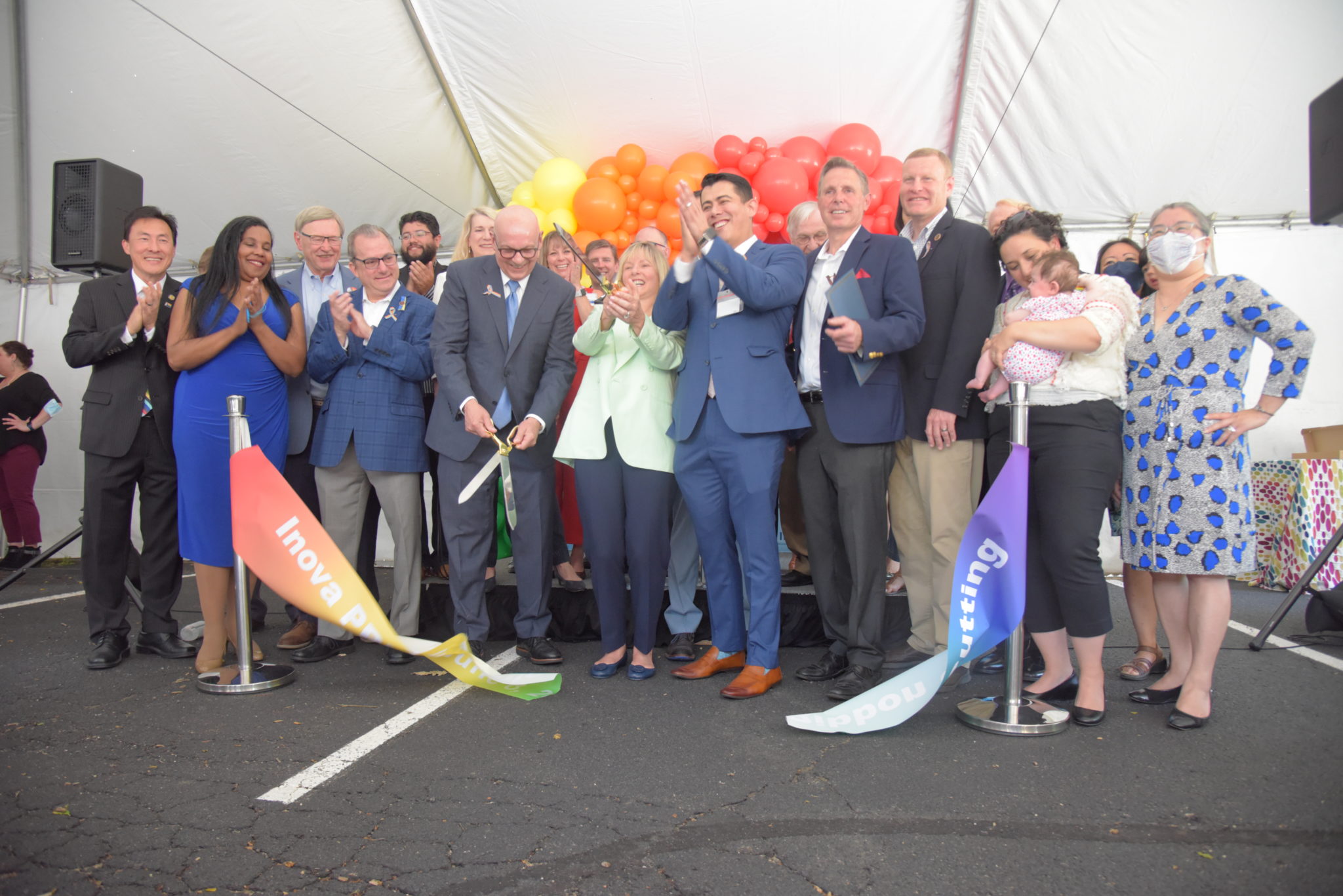 Inova officials and city council members cut the rainbow pride ribbon to the pride clinic in falls church 