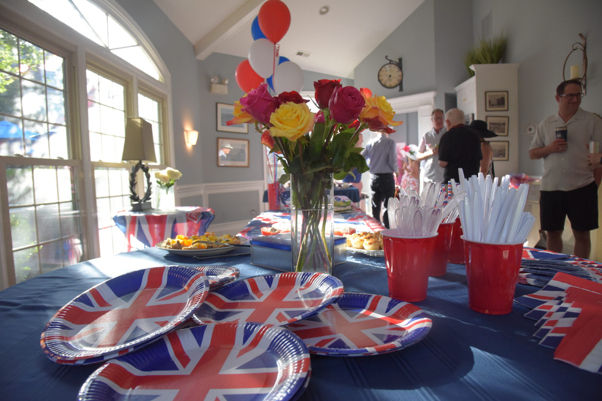 a buffet table with flowers and English Flag dishes