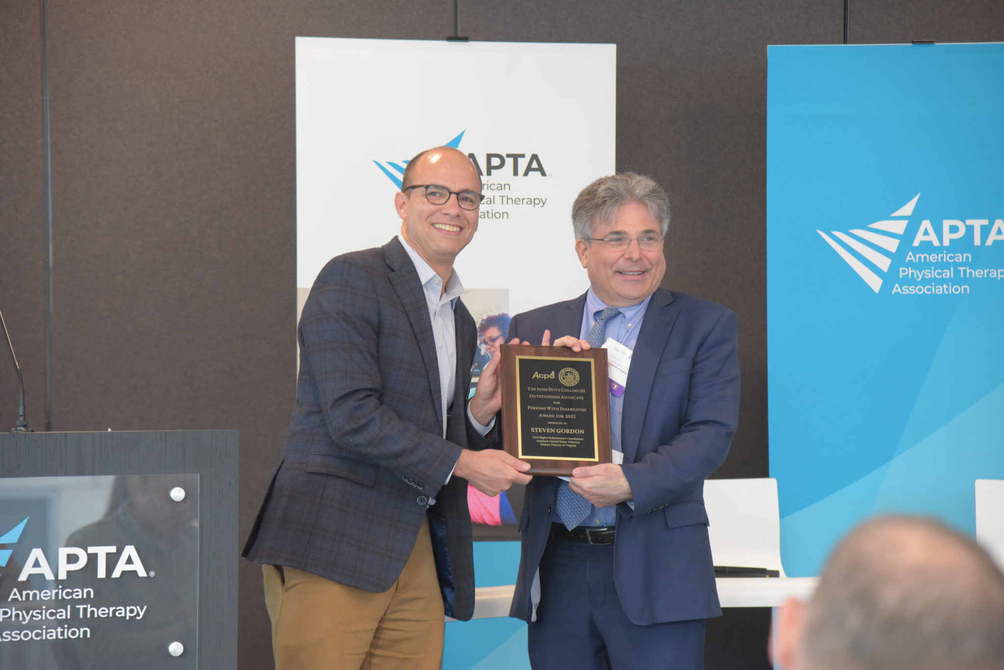 a man and mayor wilson stand next to each other holding a plaque for a disability award