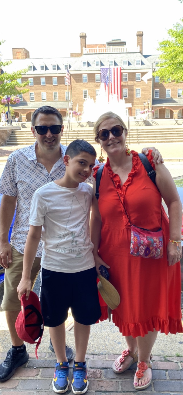 a family of three, man, boy, woman, smile at Alexandria's Market Square