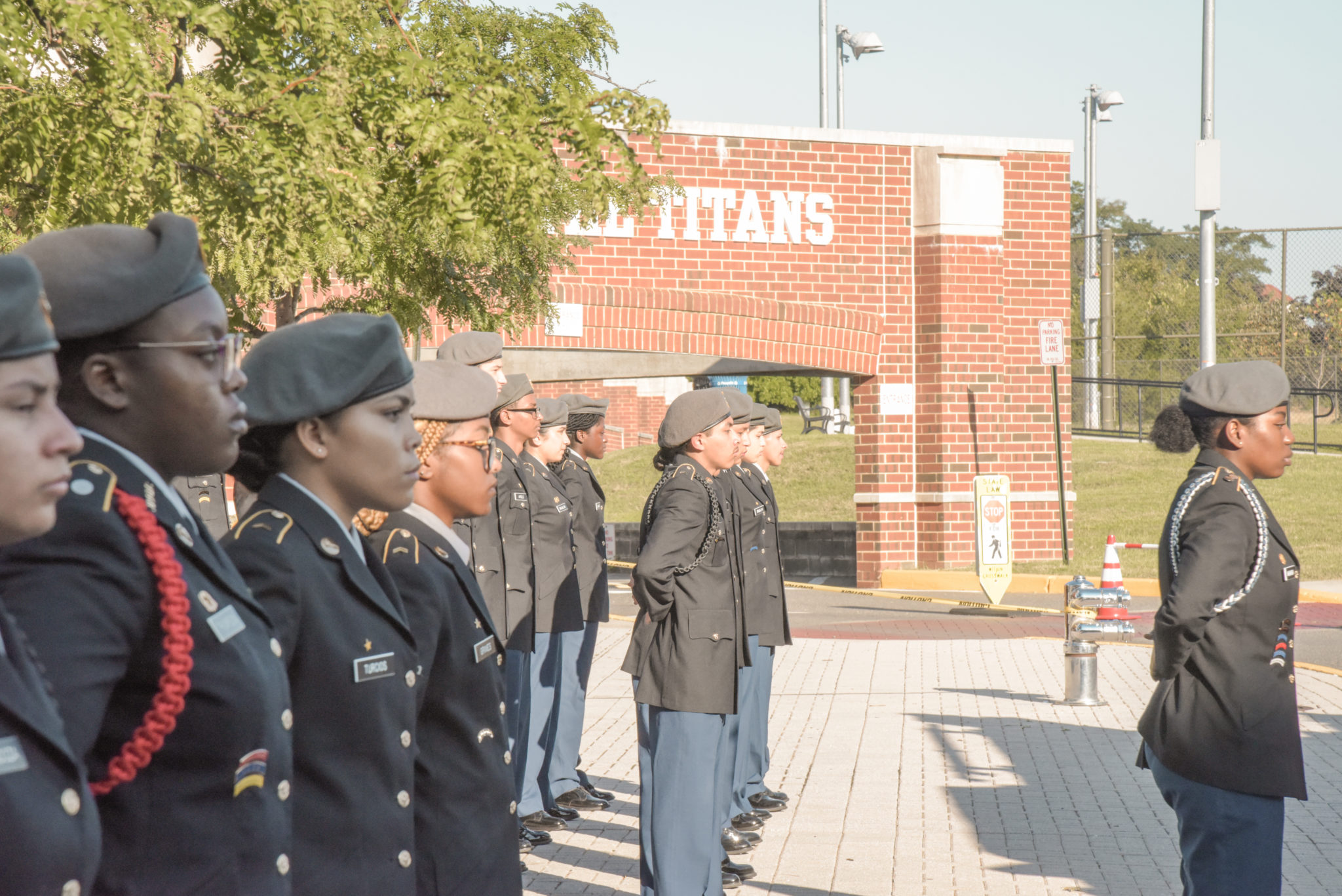 The ACHS JROTC in formation in front of the stadium Titans sign