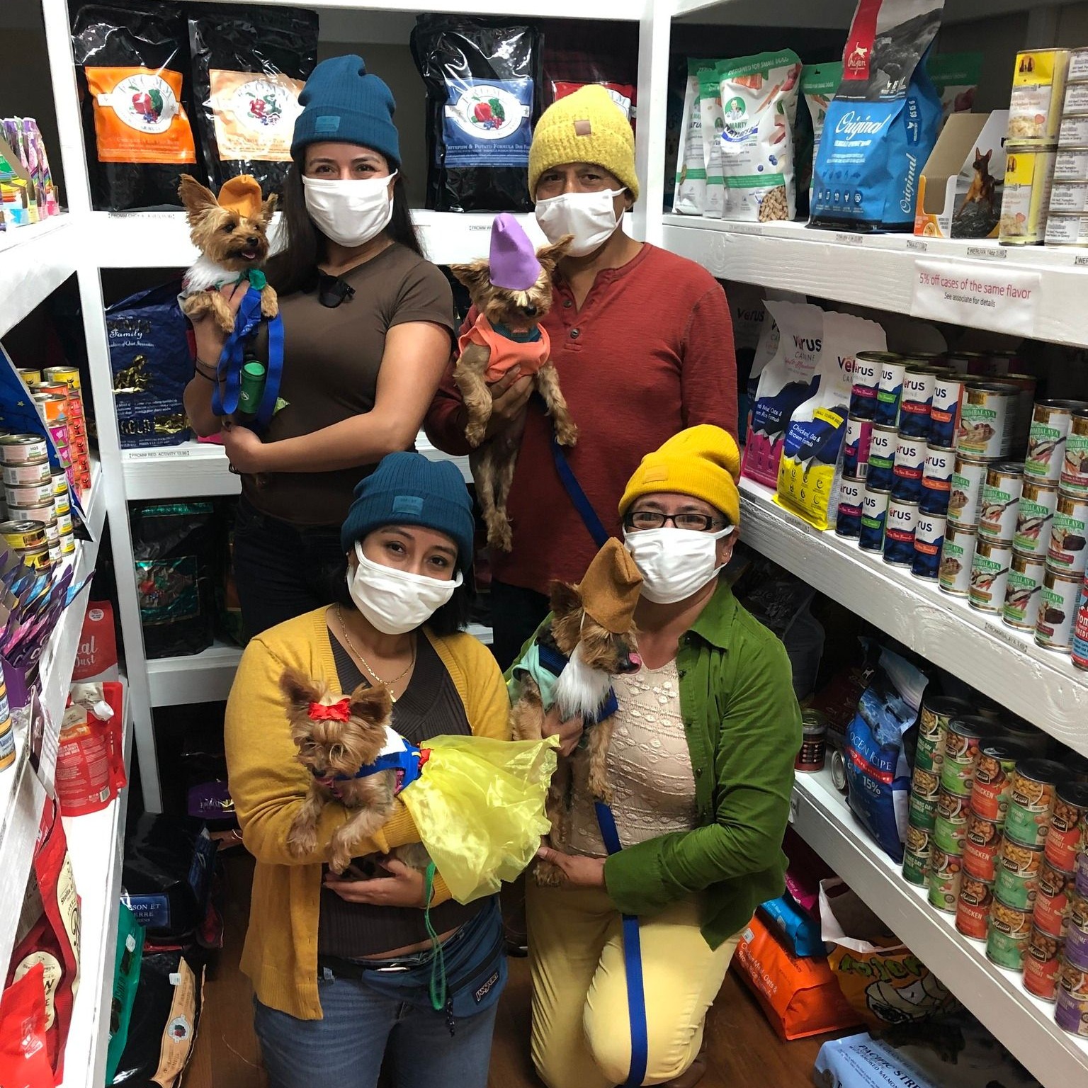 a group of four people all in colorful costumes with dogs