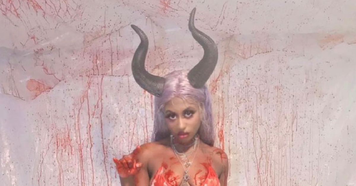 a woman standing in horns and fake blood for halloween