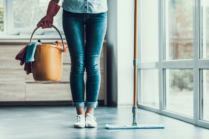 woman holds supplies to clean up after rodent infestation