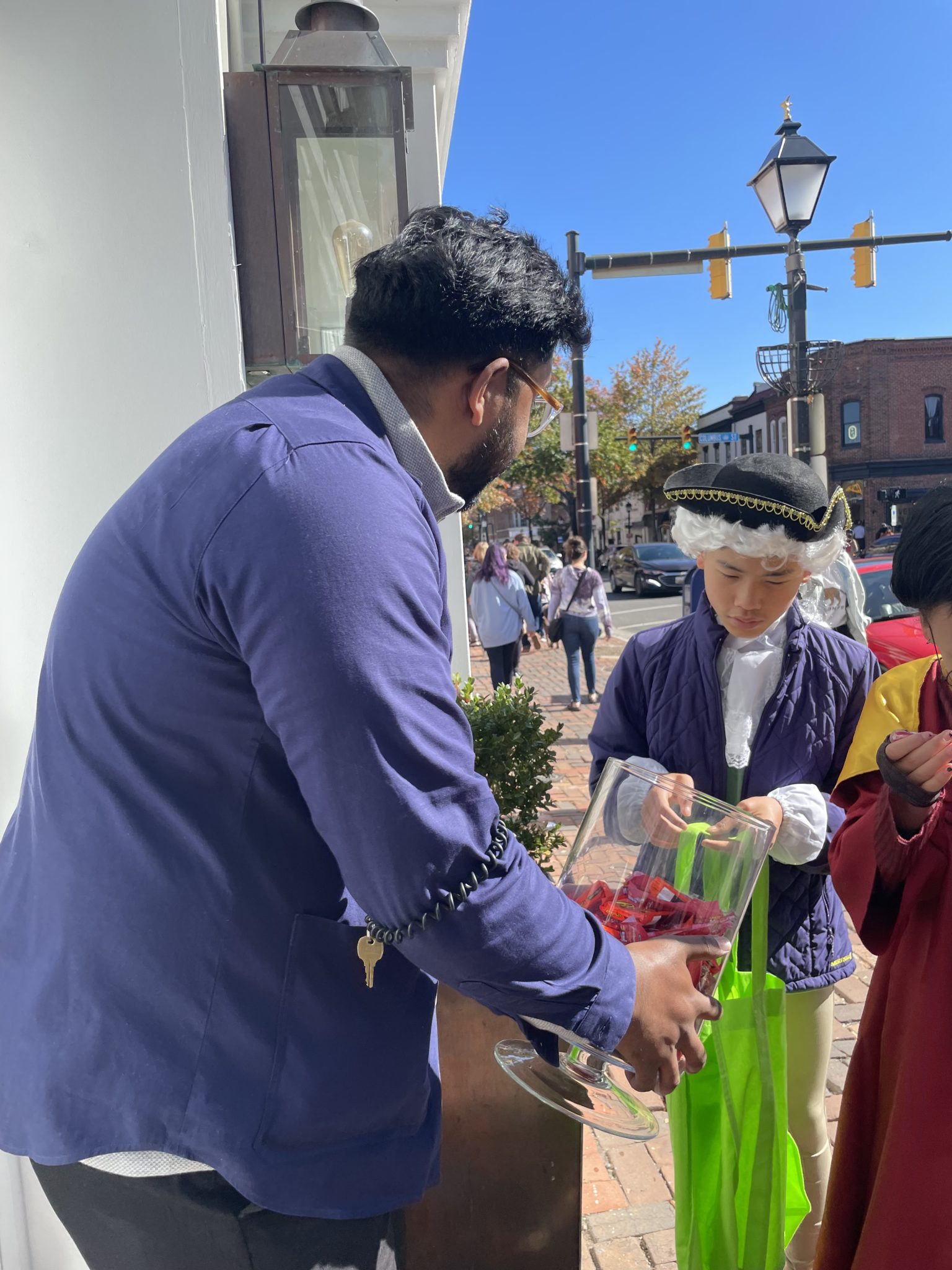 Councilman Canek Agguiree hands out candy to children dressed in colonial garb