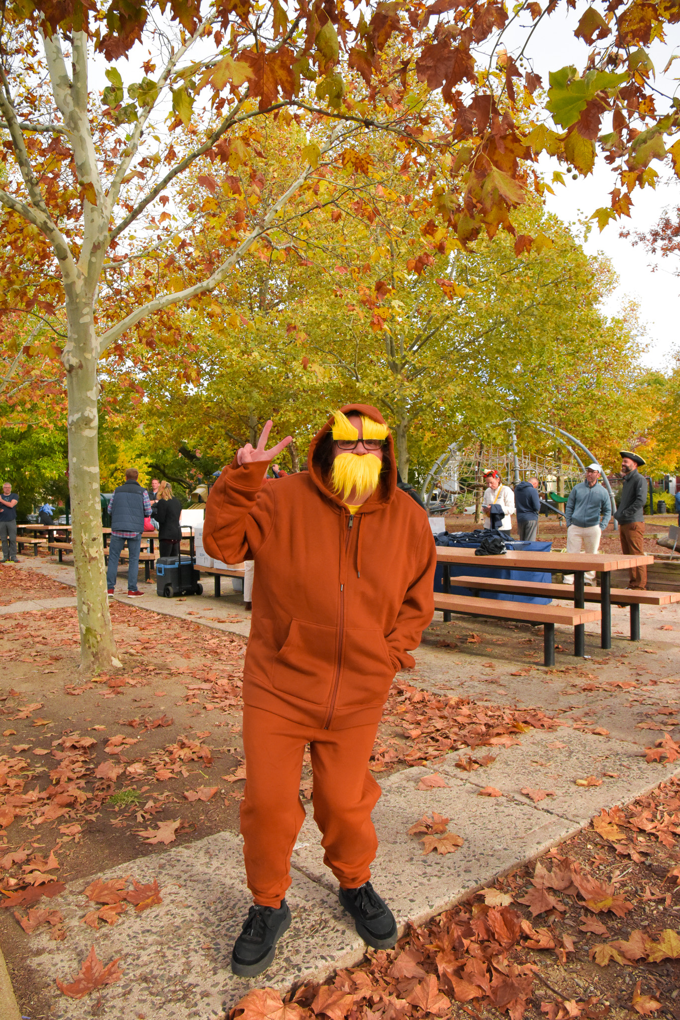 a woman dressed up as Dr. Suess's The Lorax holds up a peace sign 