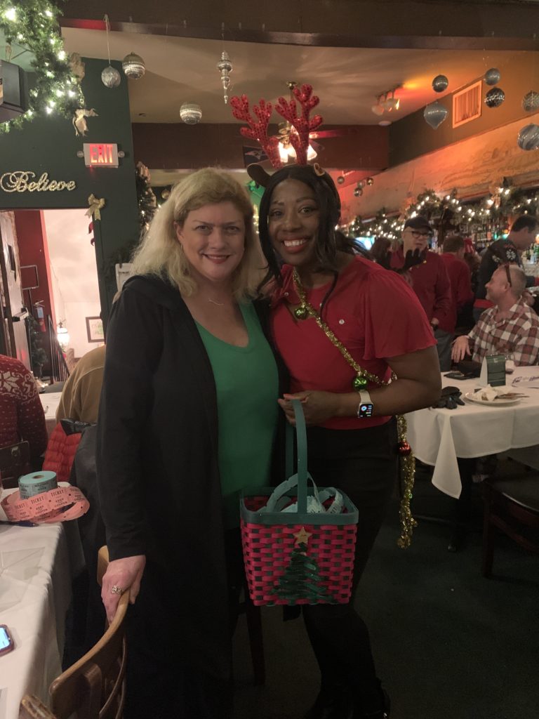 two women posing at holiday party