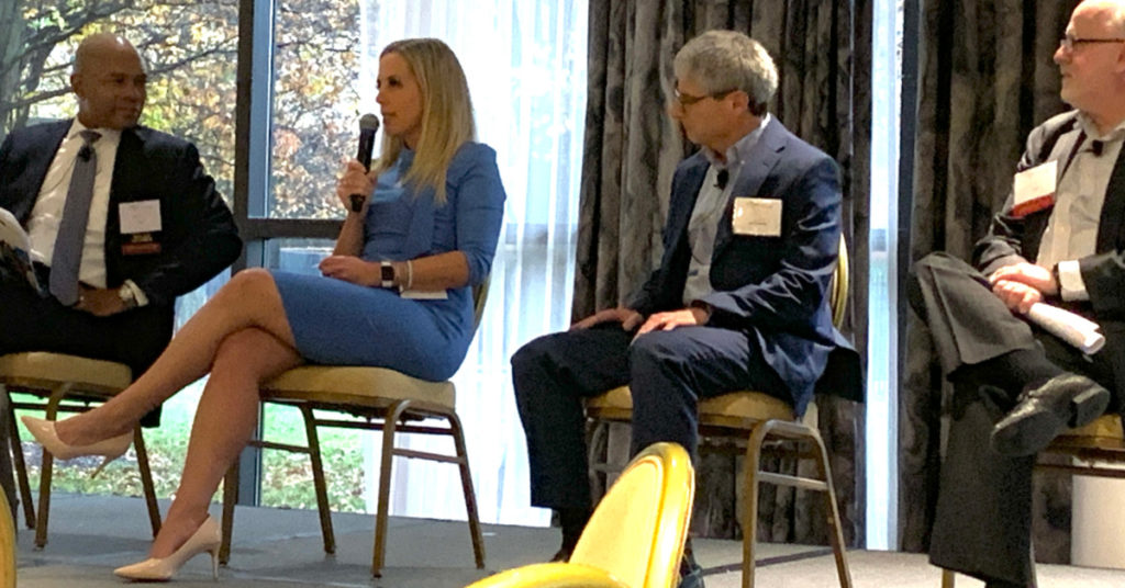 four people sitting on chairs at meeting