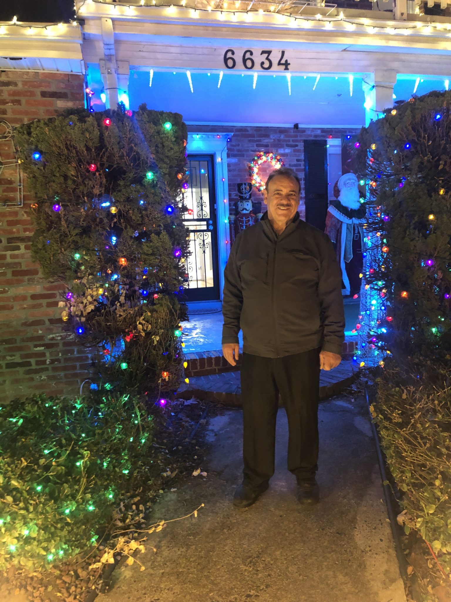 man in yard with Christmas lights