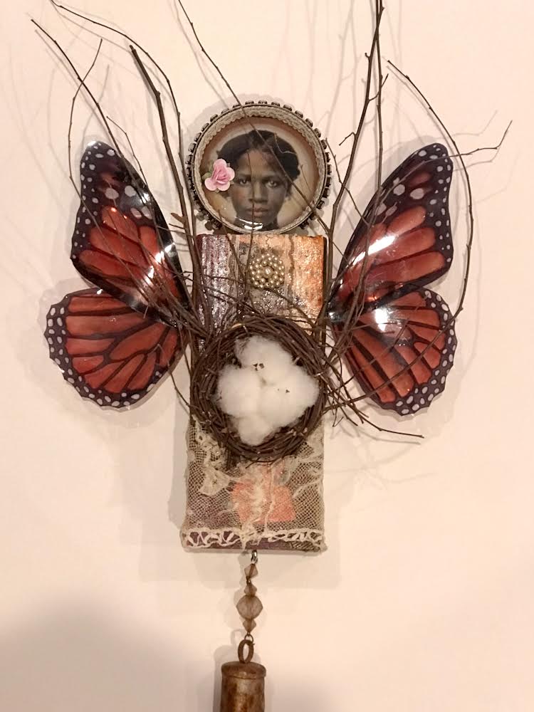 sculpture portraying antique picture of womans face and butterfly wings