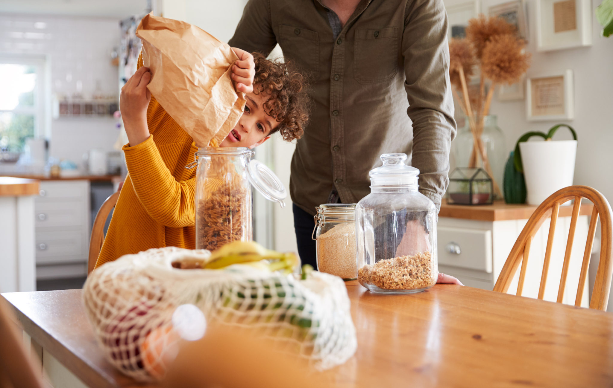 Father and son transferring snacks to glass container. (Photo: monkeybusinessimages via istockphoto.com)