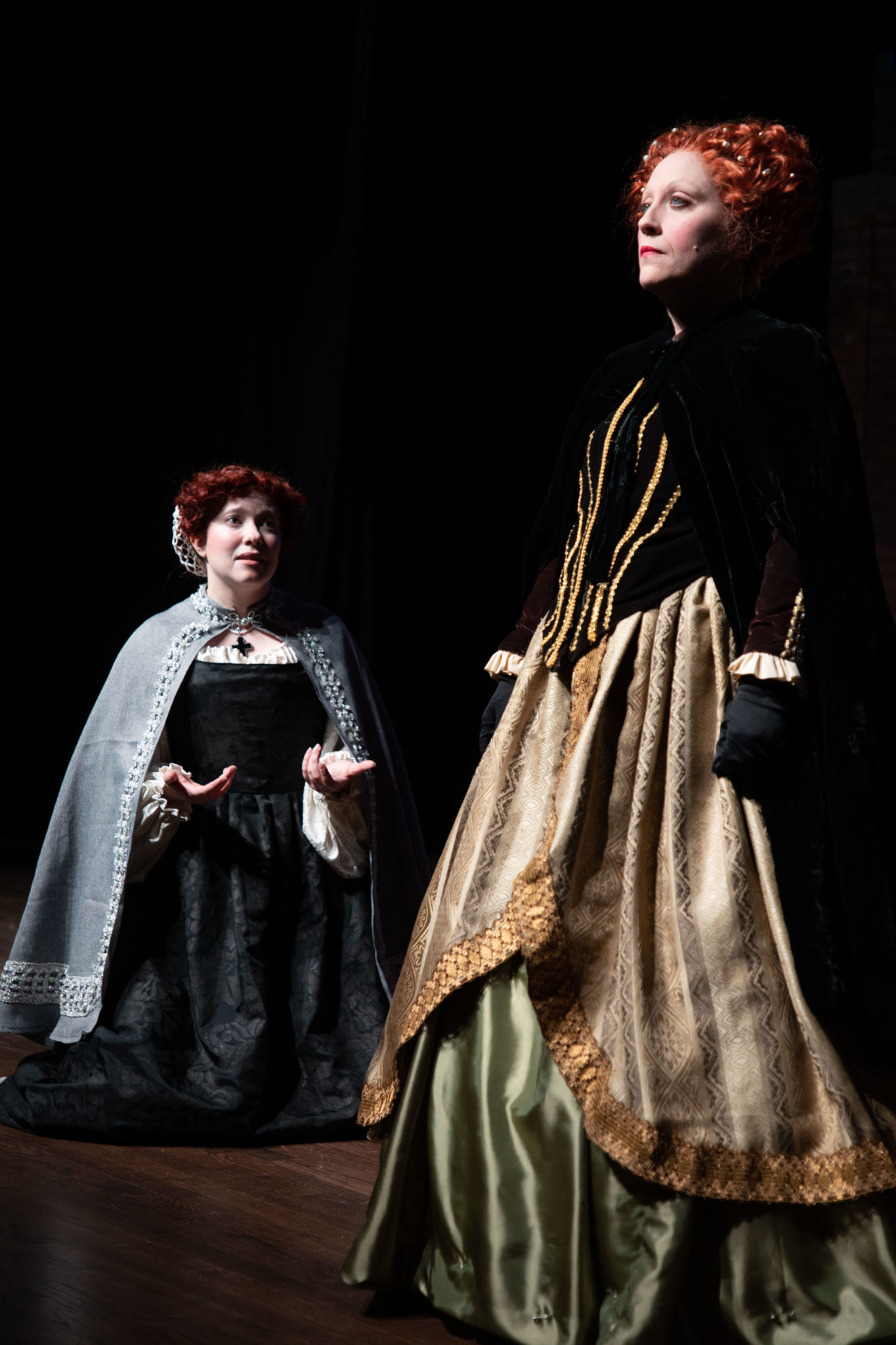 Two women on stage in Elizabethean costume.