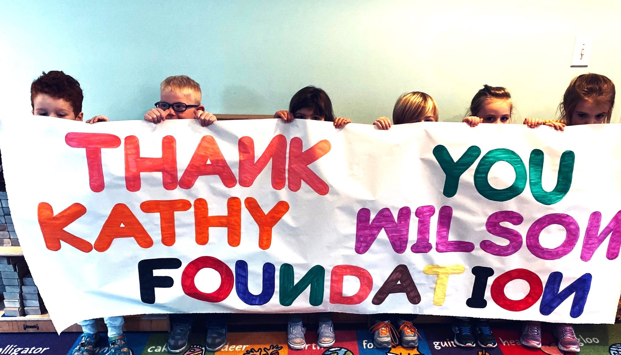 Preschoolers hold a Thank You banner for the Kathy Wilson Foundation. (Courtesy photo)
