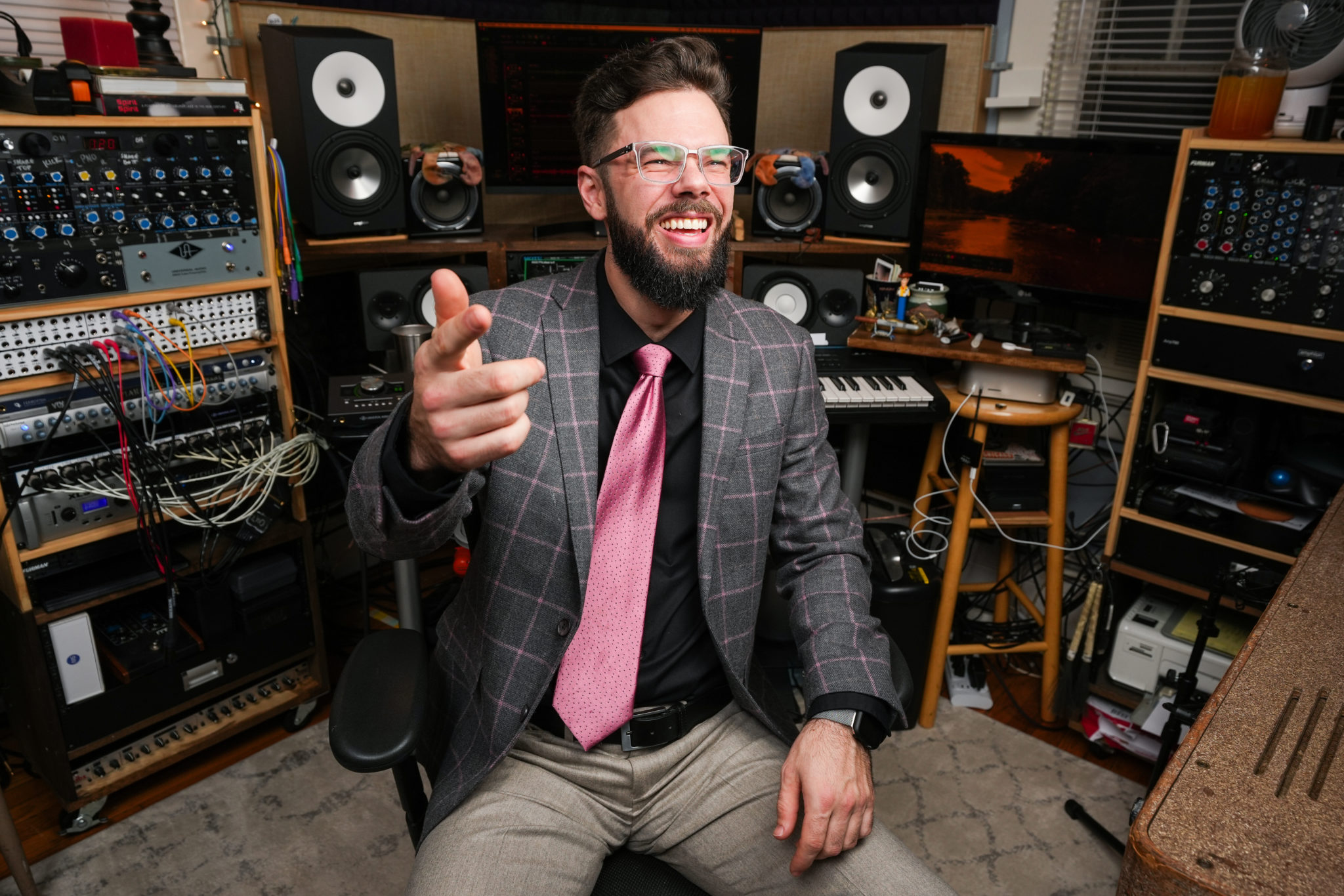 man in coat and pink toe with musical instruments all around him