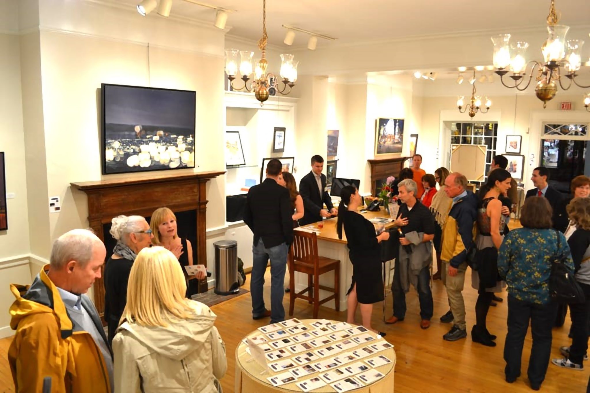 People standing in an art gallery having cocktails.