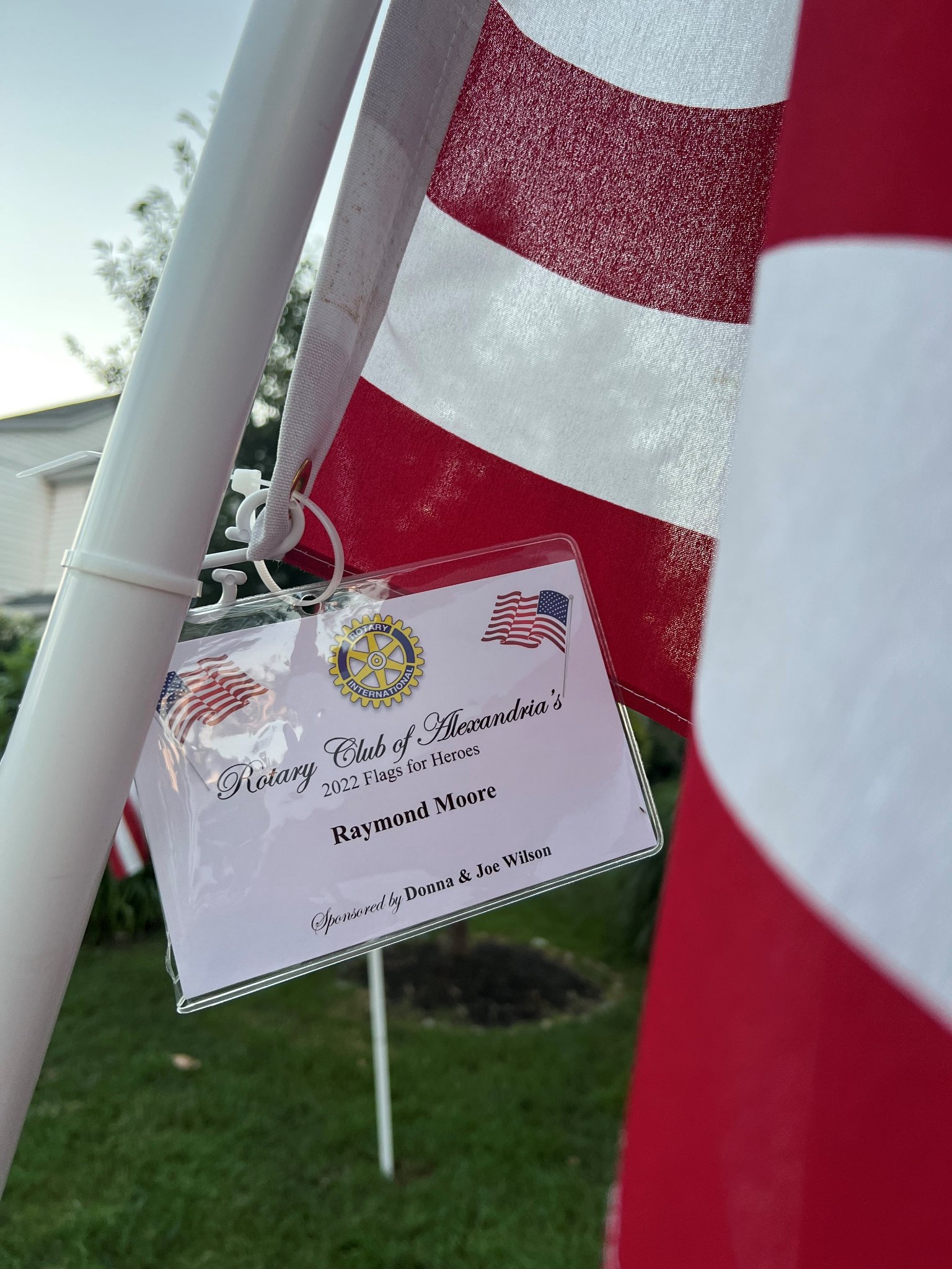 Commemorative plaque attached to flagpole of American flag in Flags for Heroes event.