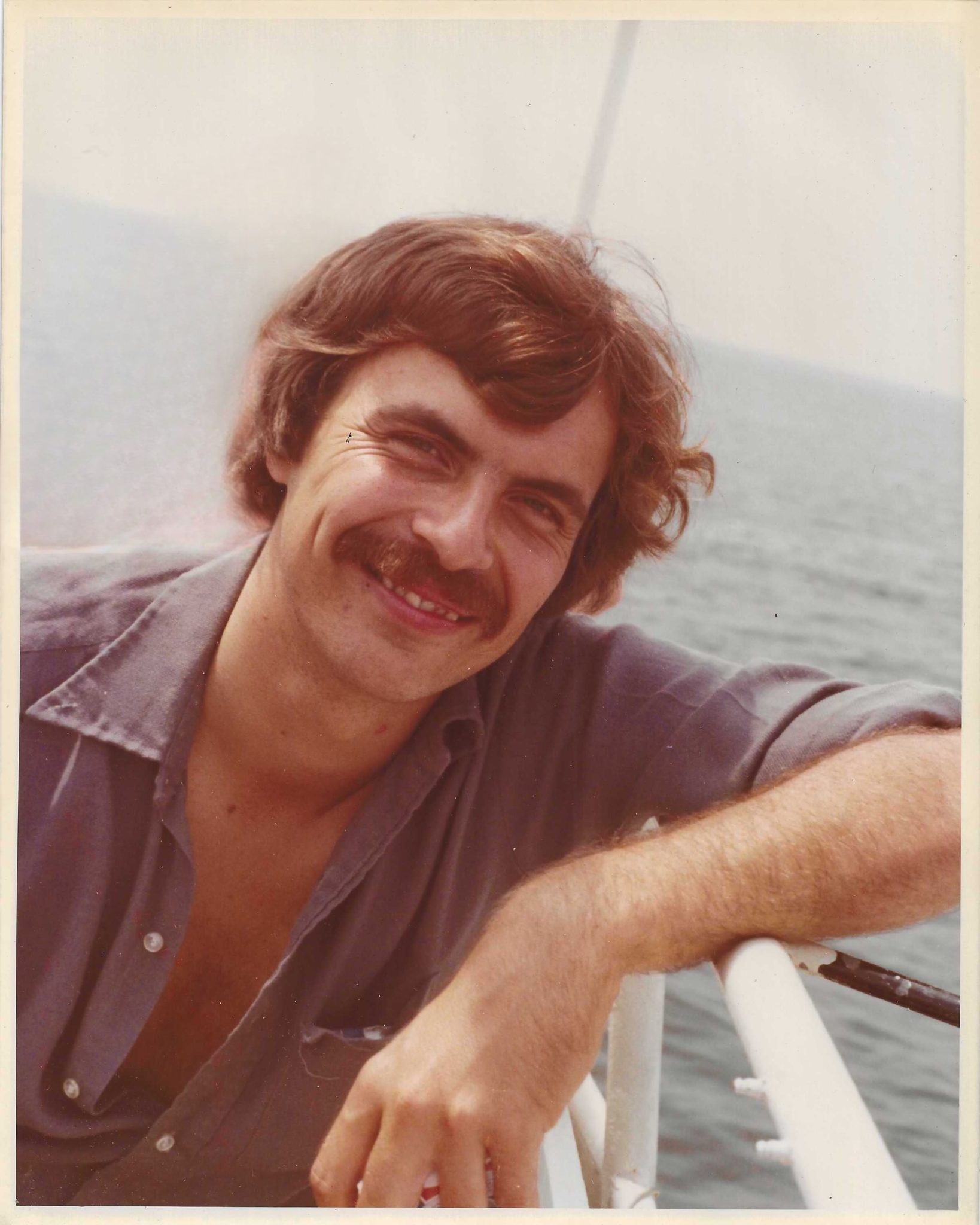 middle aged man smiling with moustache on a boat