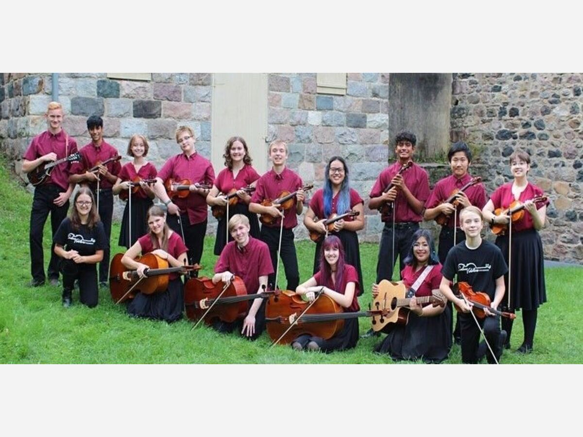 A group of kids in maroon shirts and black pants all holding a musical instrument.