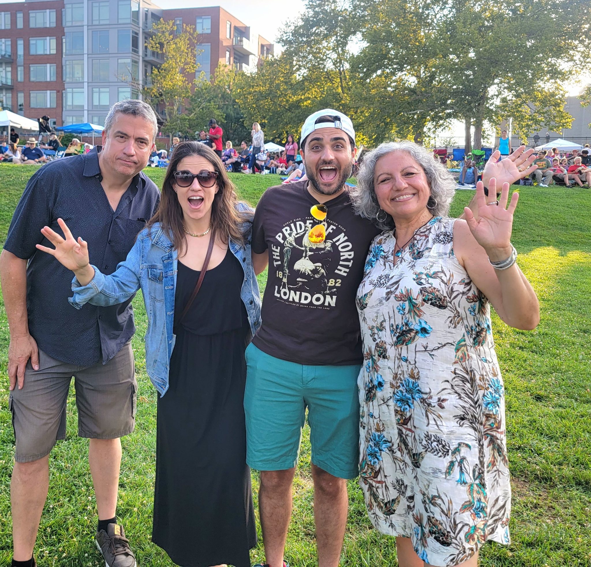 Four adults waving at camera