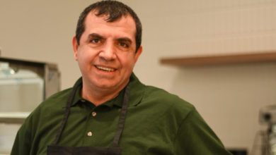 man standing at counter staring at camera.