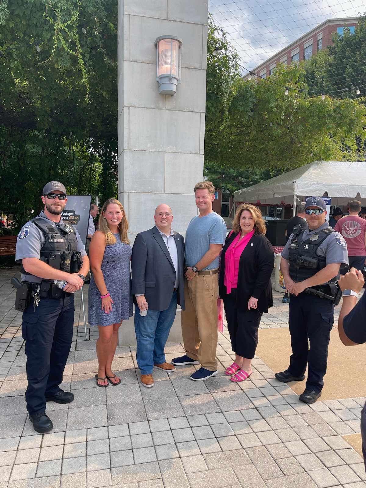 People gathered with two police officers looking at camera smiling.