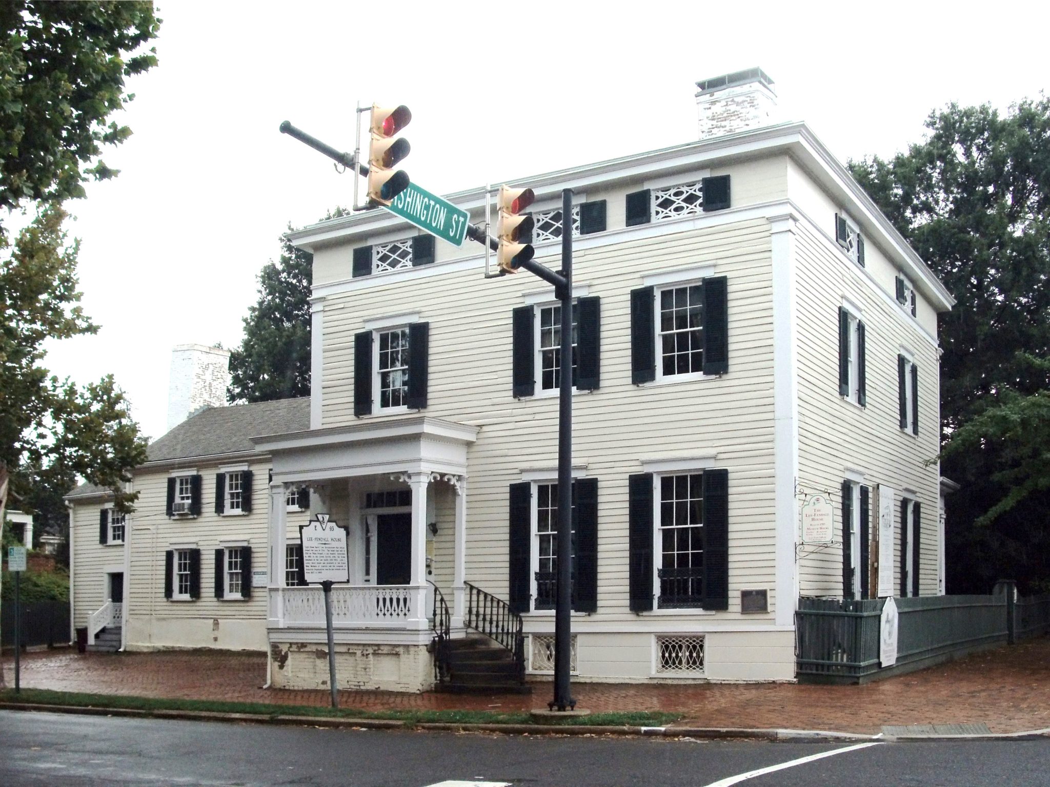 18th century white wood-clapboard two story building with black shutters.