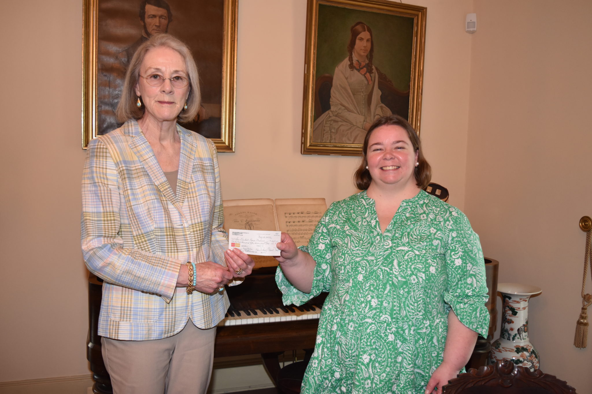 Two ladies holding a check between them.