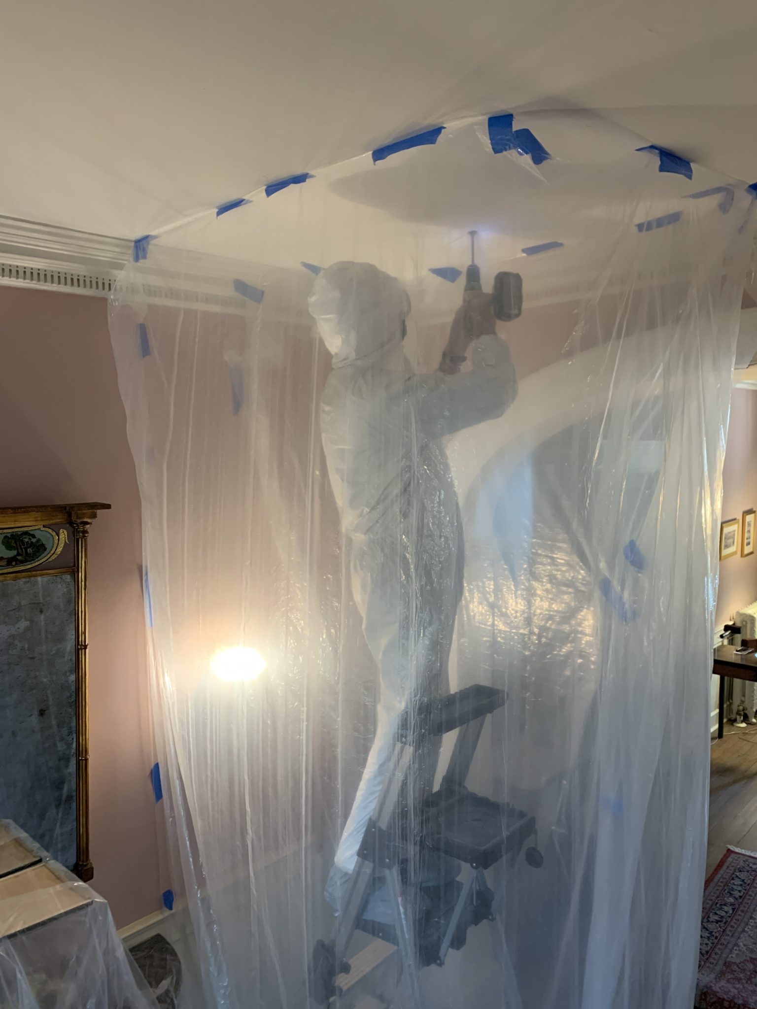 Man working inside a net on a ceiling taking a digital survey.