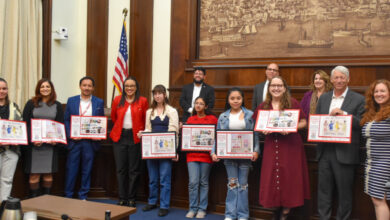 group of children and adults in fron of wood dais where Alexandria City Council is sitting.