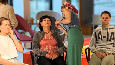 Three women seated and another woman is applying accupuncture needles to one of the seated women's ears.