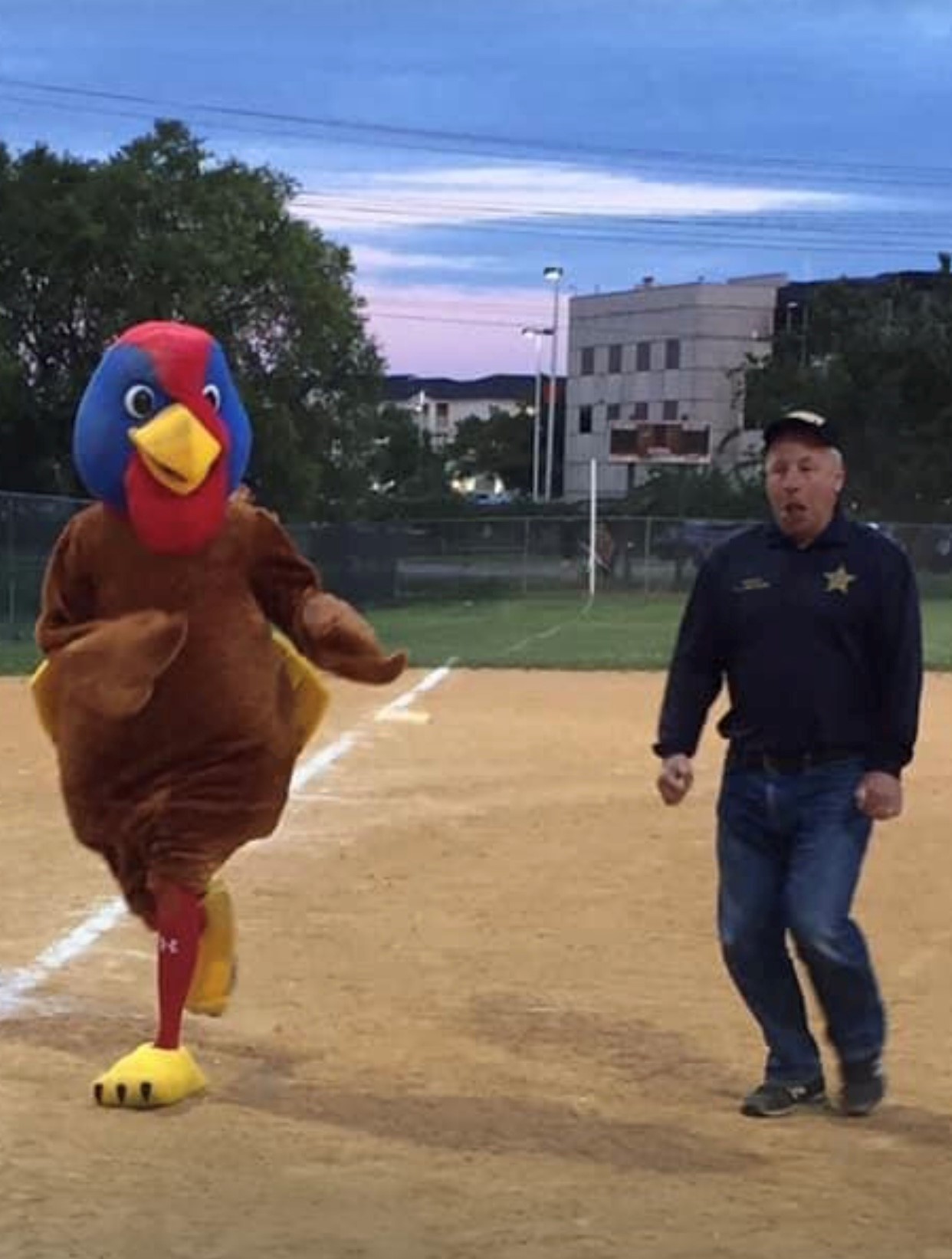 Turkey mascot and senior man in ball cap.