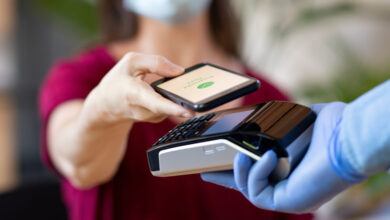 woman holding smartphone over a small pay reader in a man's hand