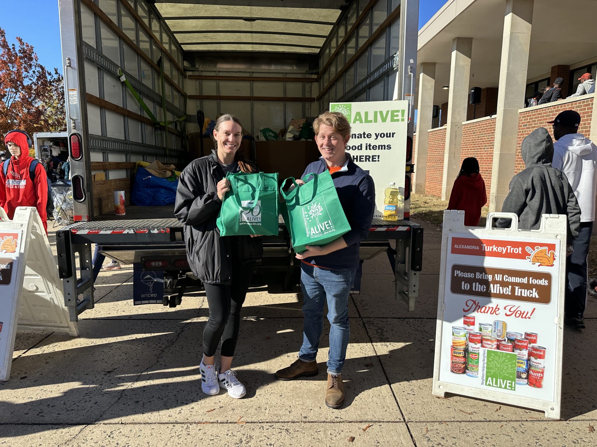 Two people holding green bags.