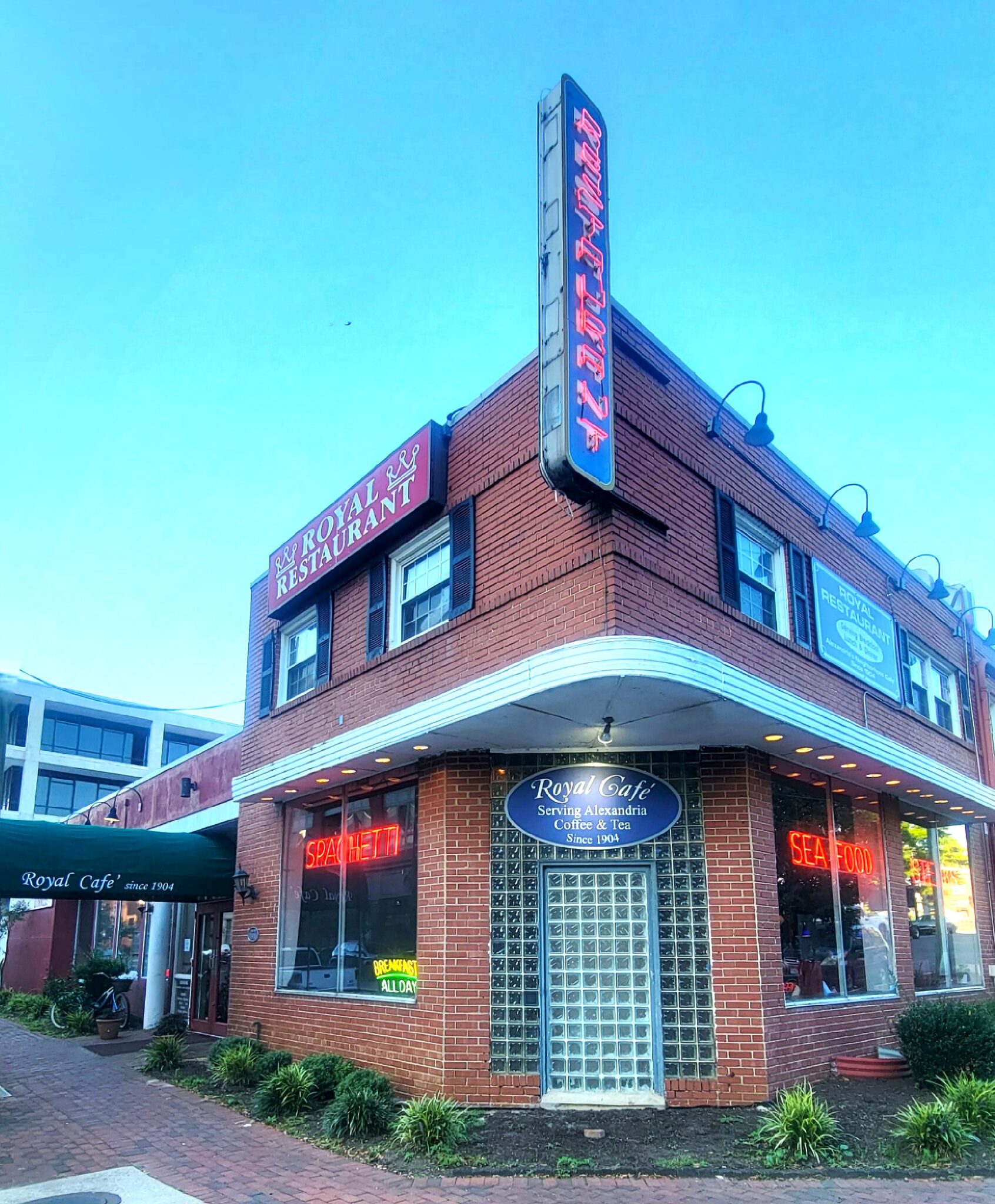 Brick building with iconic neon sign spelling out Restaurant vertically.