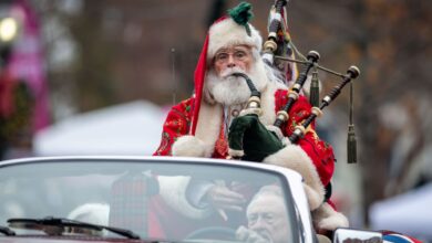 Santa playing bagpipe in convertible in parade
