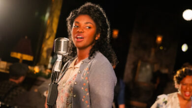 One African American lady singing at a microphone.