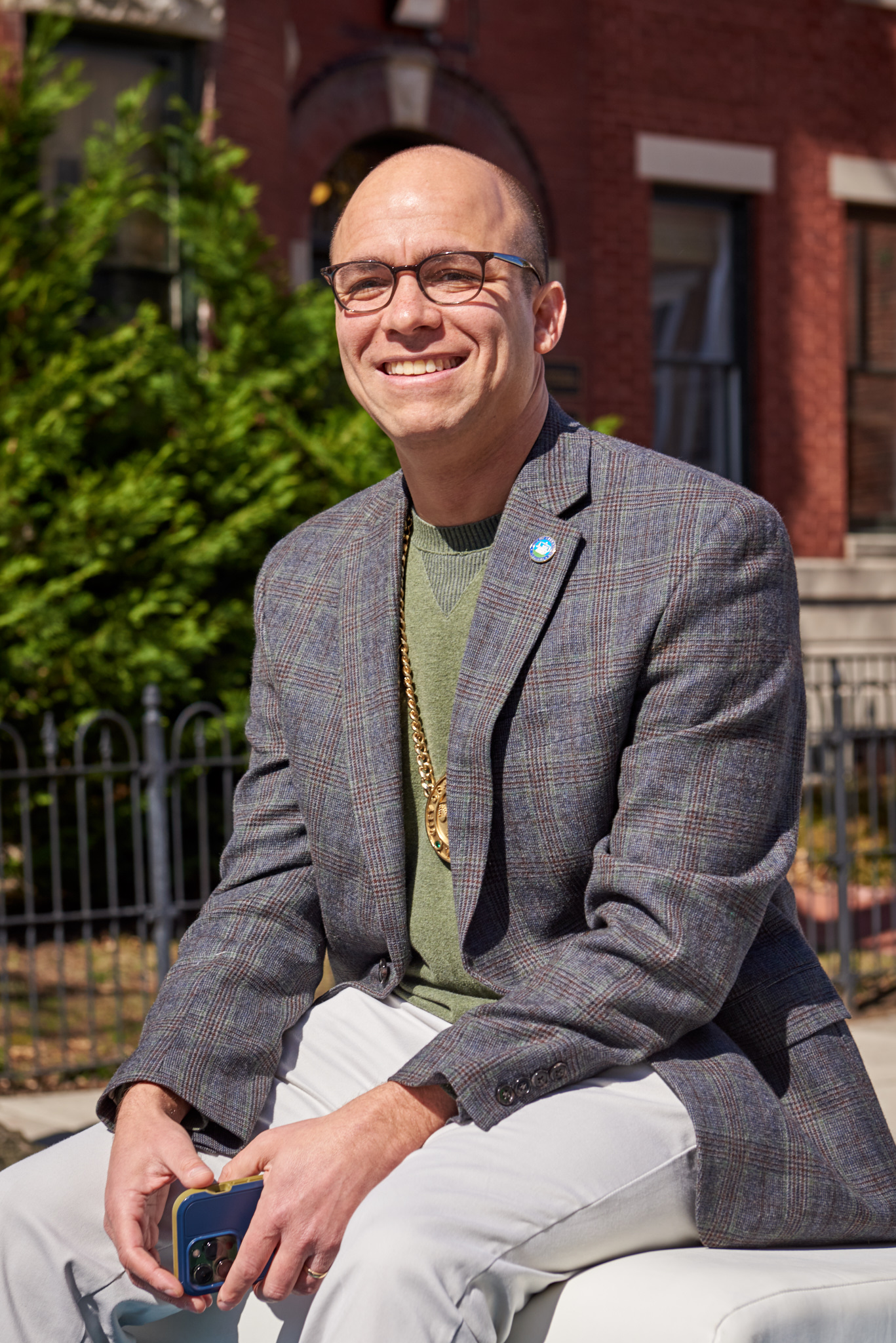 Caucasian man smiling in blazer and tee shirt.