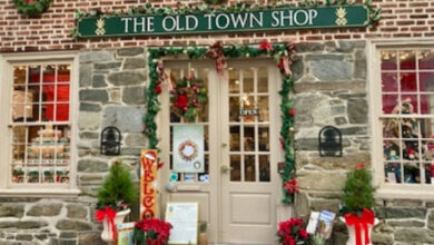 Stone fronted exterior of The Old Town Shop in Alexandria, VA decorated with holiday wreaths and bows.