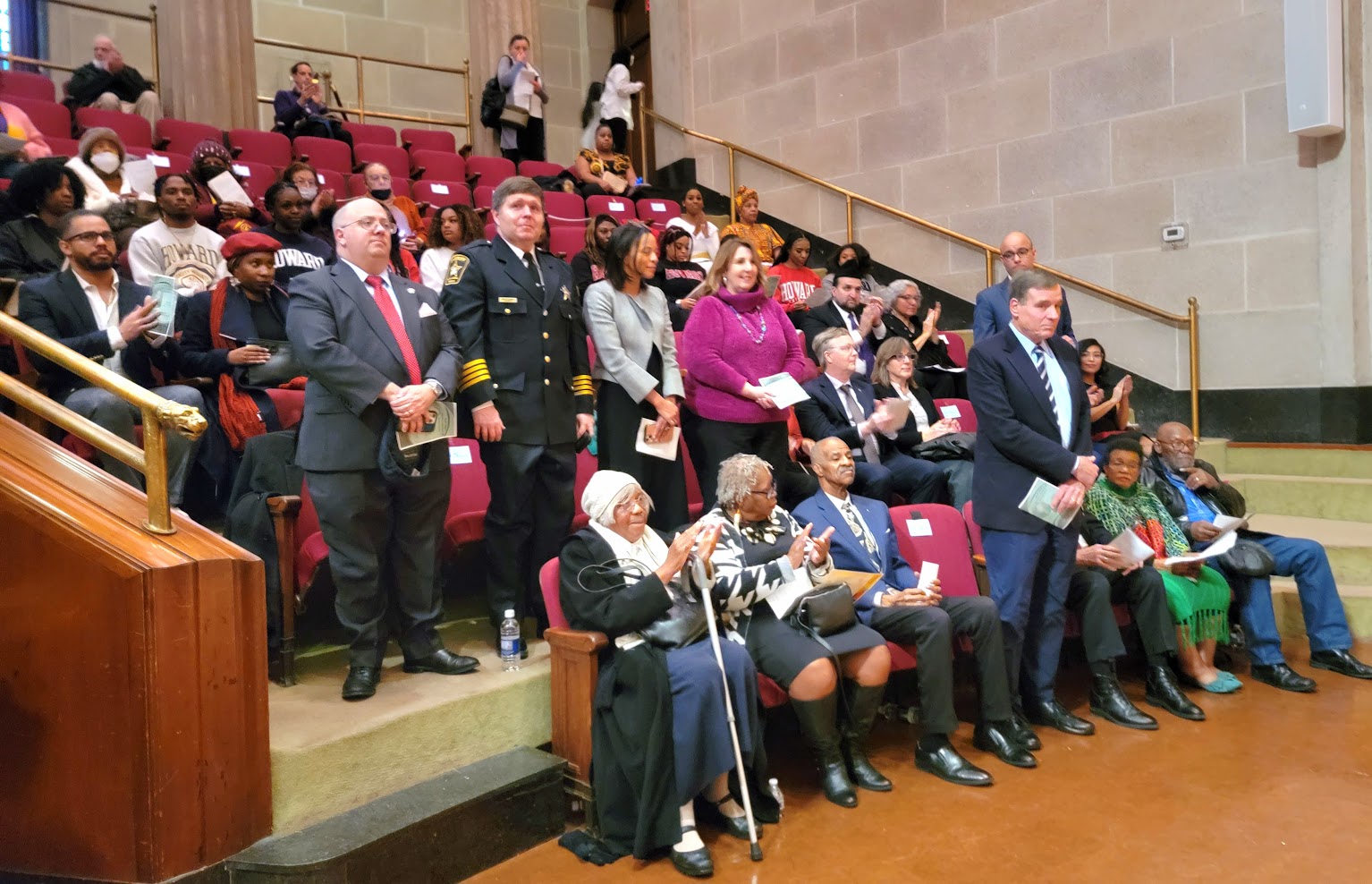 A crowd of people assembled in theatre seating.