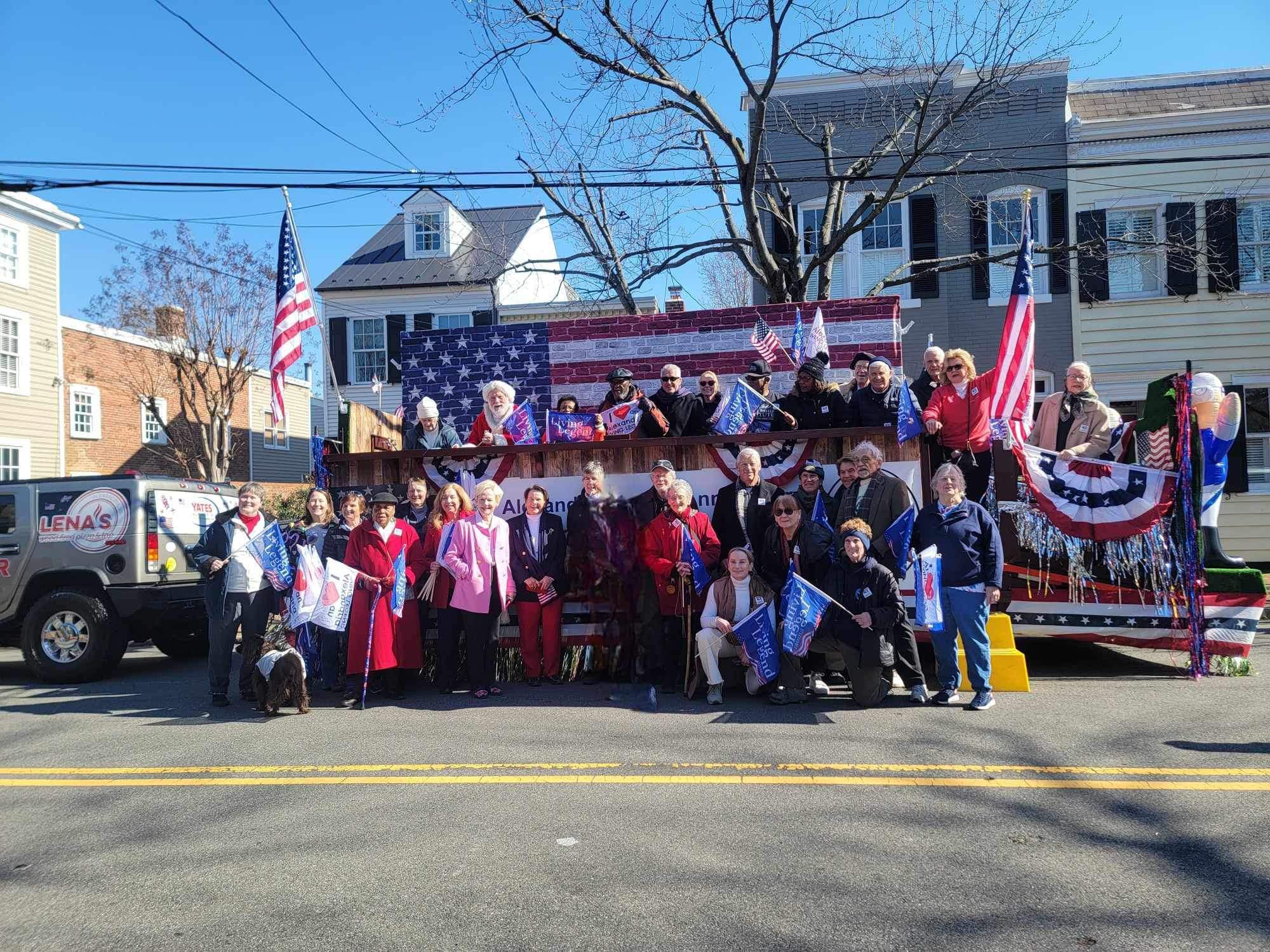 Group of people standing in front of a parade float.